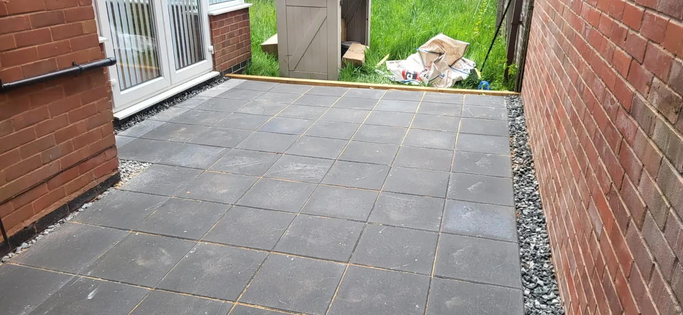 After: Broken tarmac dug out and a new slab patio laid with gravel edging.