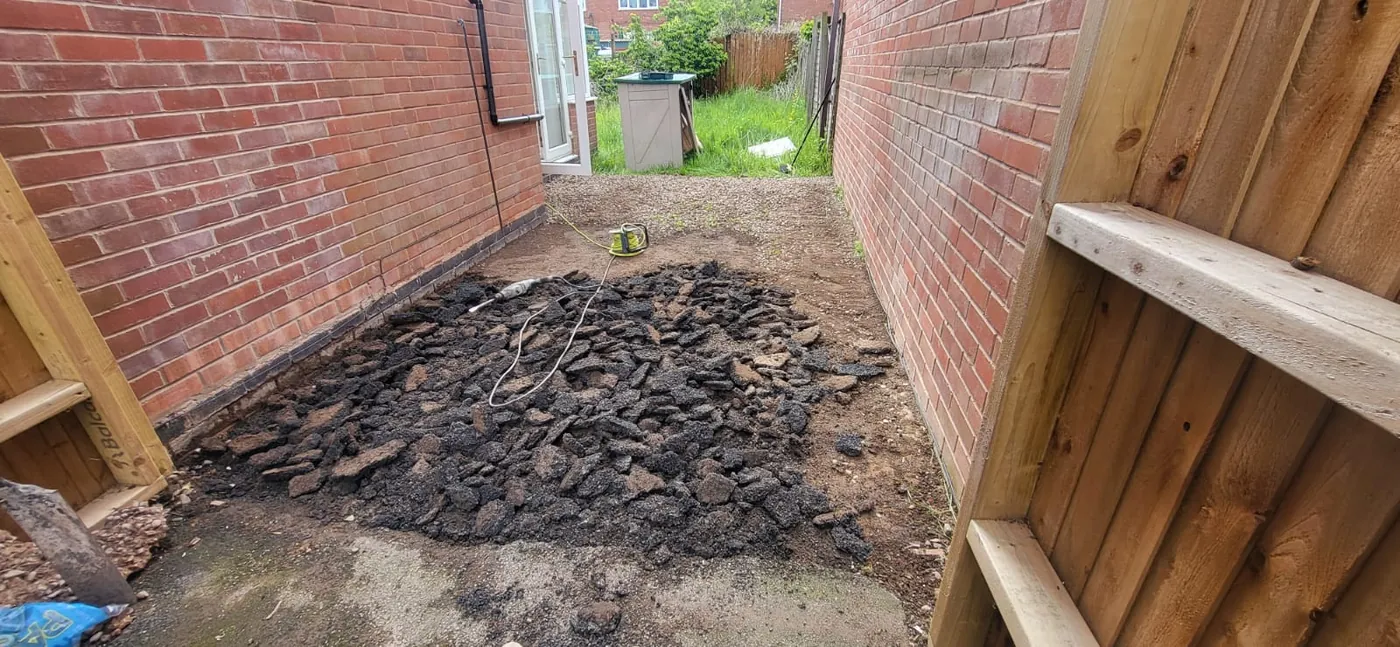 Before: Broken tarmac dug out and a new slab patio laid with gravel edging.